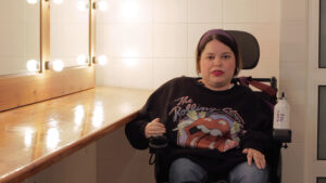 Mujer con discapacidad física en silla de ruedas en un camerino
