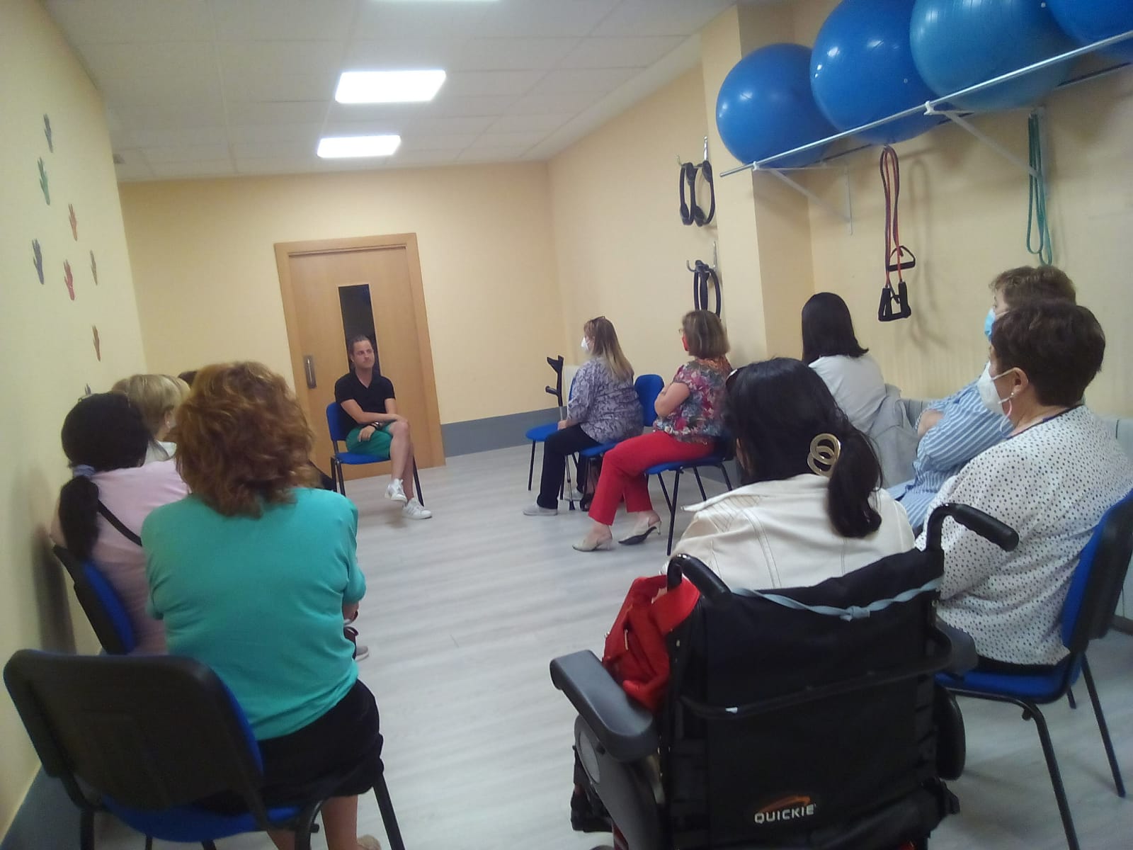 Grupo de mujeres con y sin discapacidad en interior con un hombre impartiendo un taller de AFDA