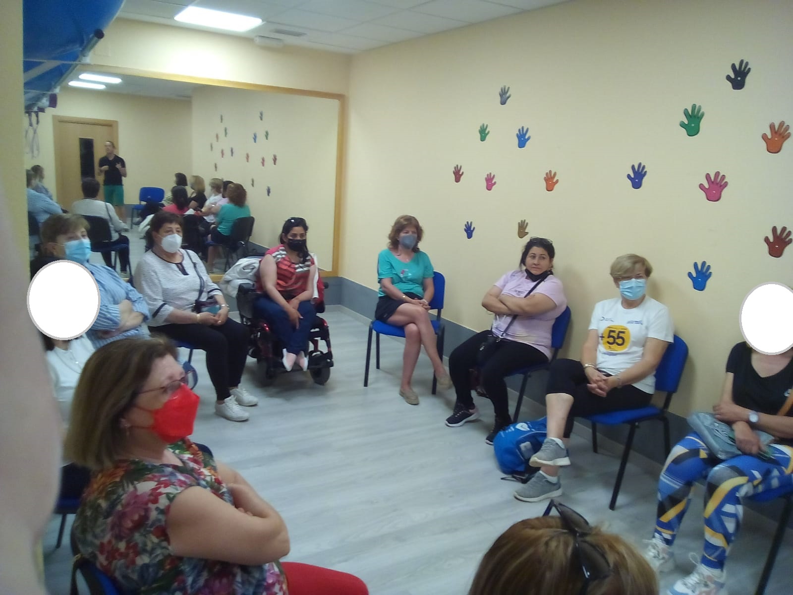 Grupo de mujeres con y sin discapacidad en interior con un hombre impartiendo un taller de AFDA