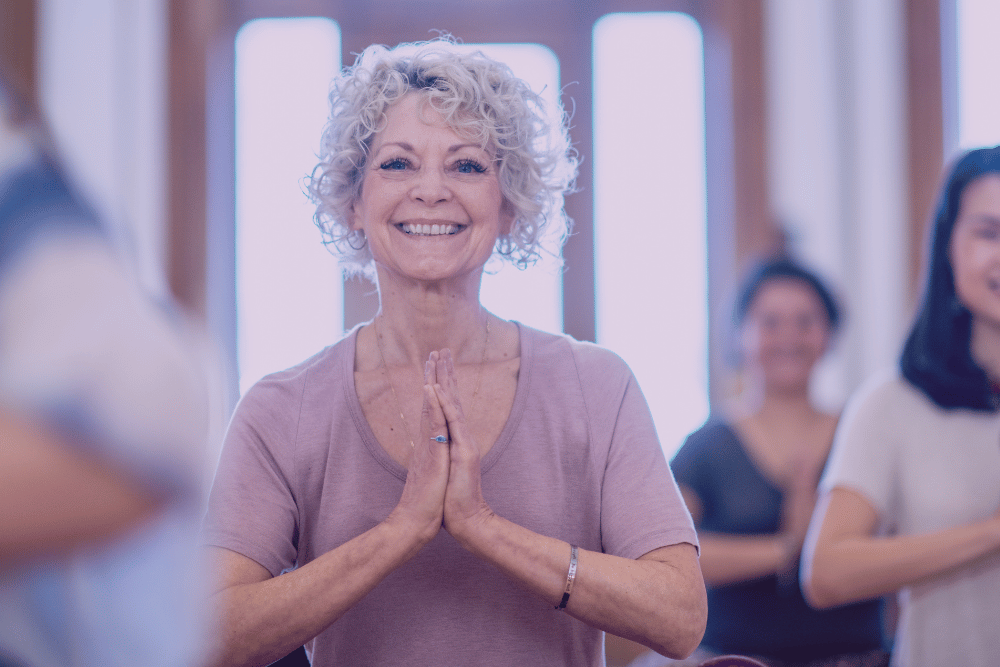 Mujer de edad avanzada haciendo yoga sonriente