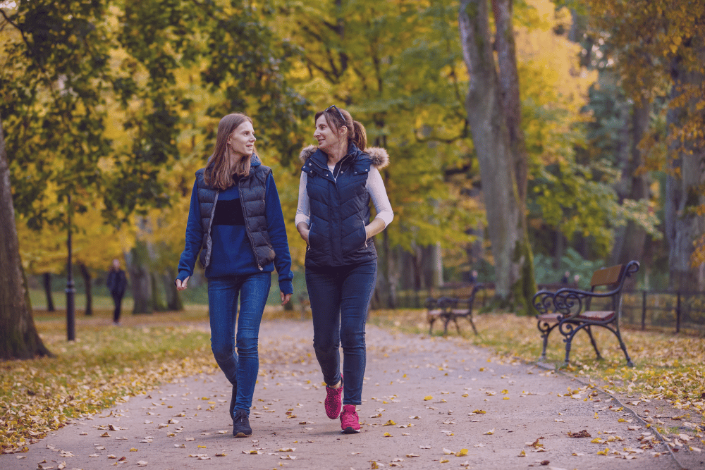 Dos mujeres caminando juntas por un parque