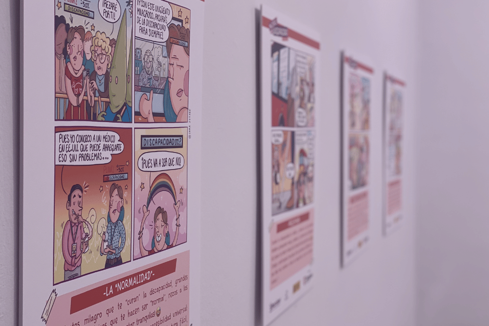 Panales colgados en una pared que muestran viñetas de cómic sobre mujeres con discapacidad